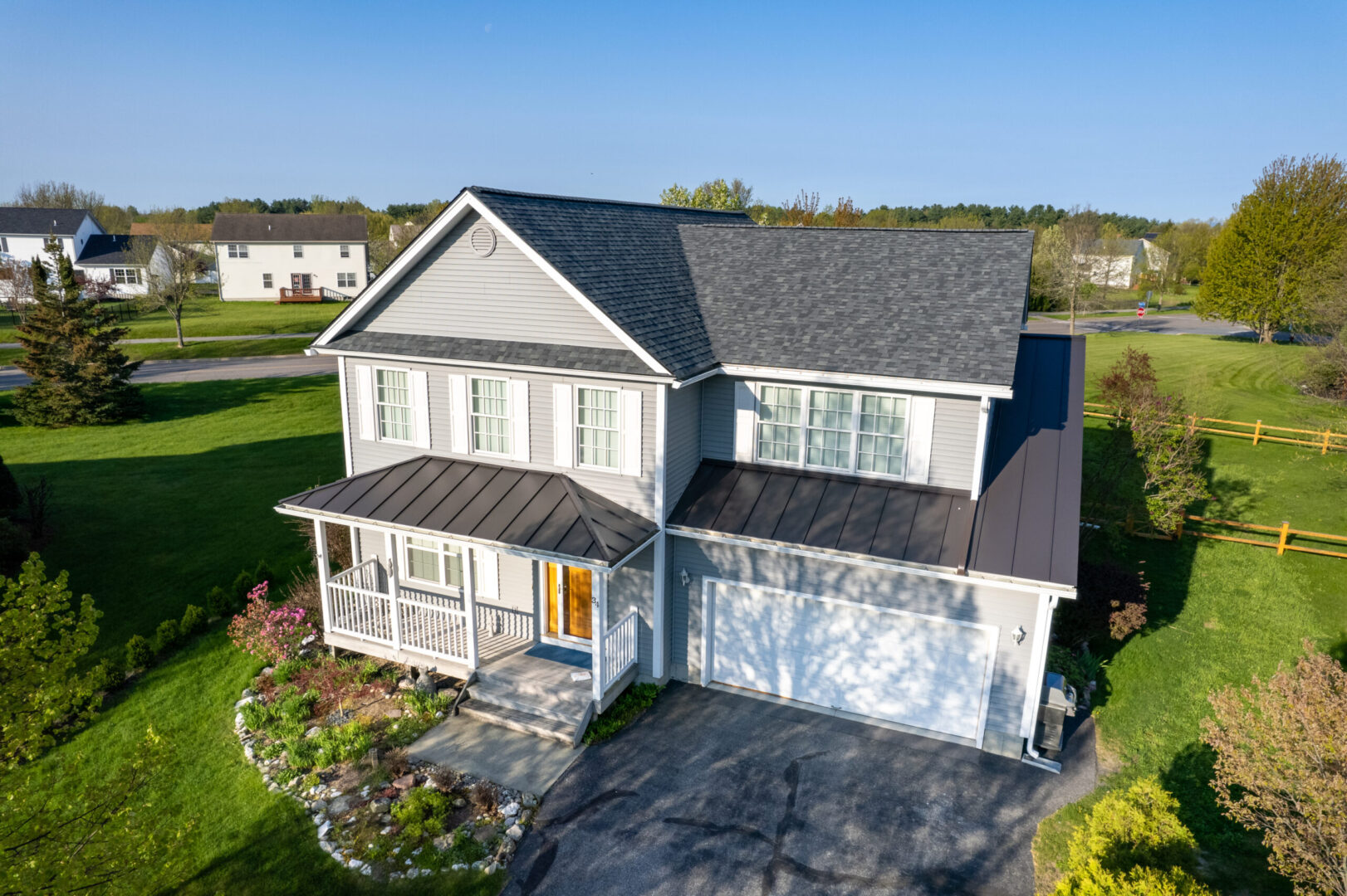 A new asphalt shingle and standing seam metal roof on a colonial style home in South Burlington, Vermont