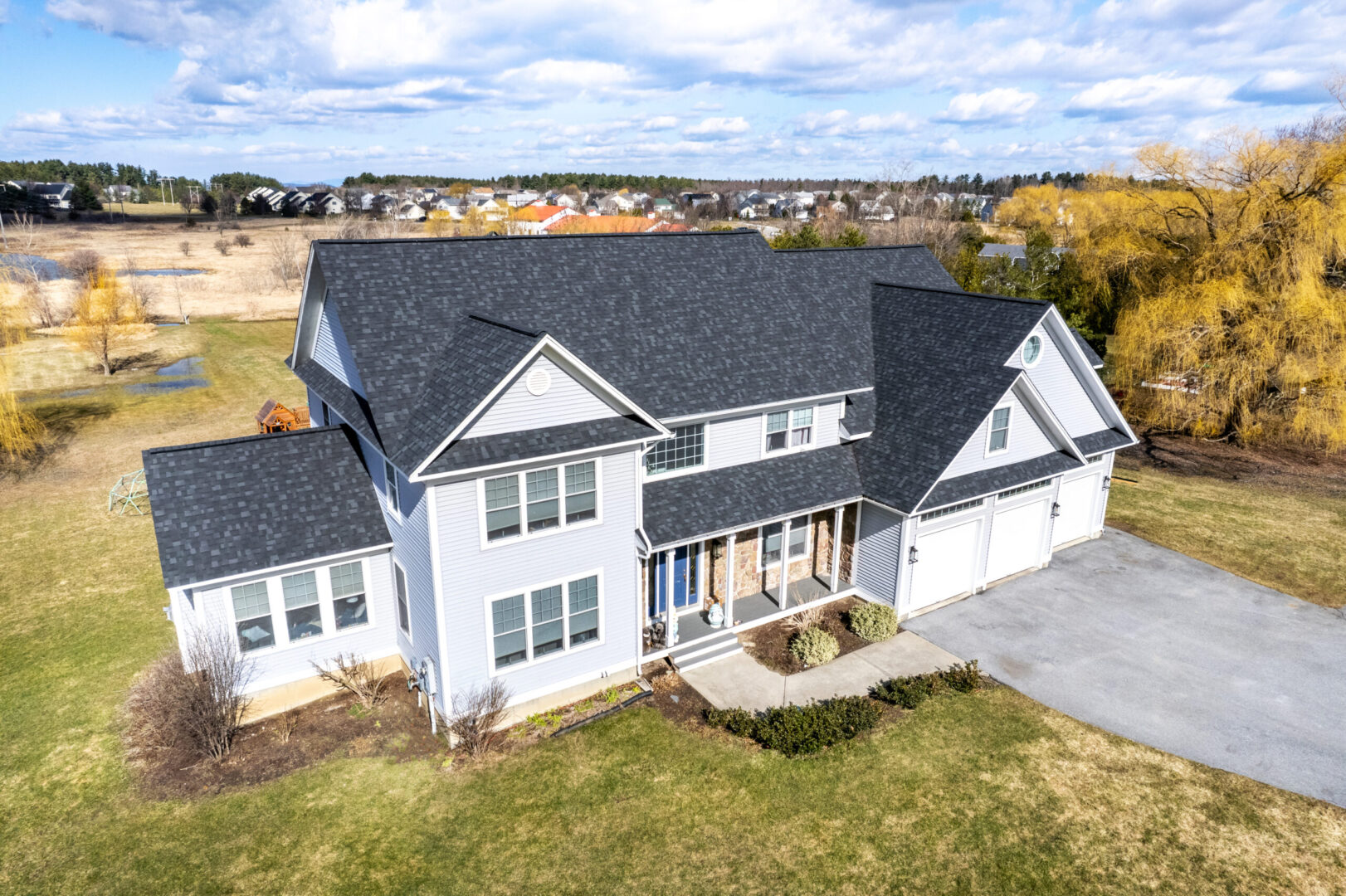 House with a new asphalt shingle roof in the spring