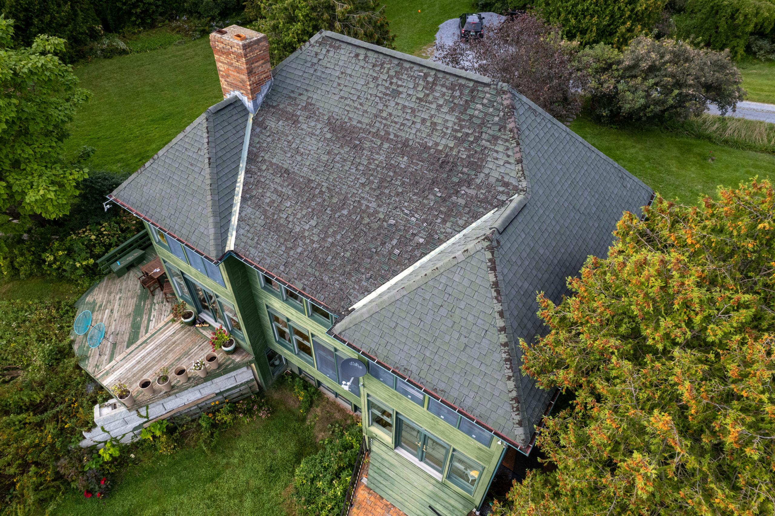 A house roof full of old shingles and damage from bats in the roof